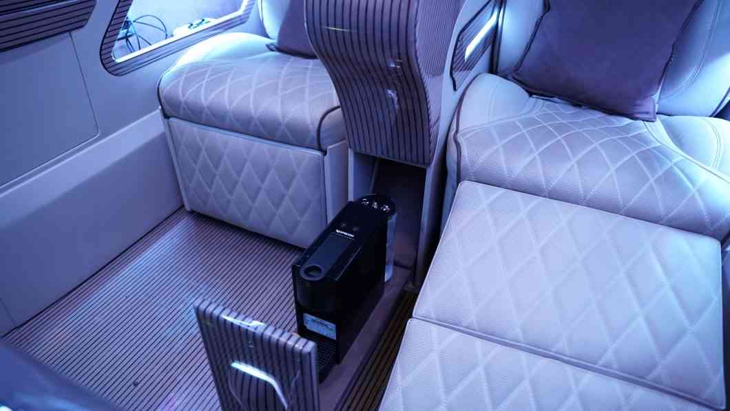 Intérieur du VTC de luxe à Paris : fauteuils cuir capitonné, plancher bois et machine à café du Van Maybach